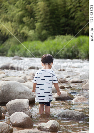 川遊びをする男の子の後ろ姿の写真素材