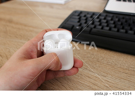 Man holding box with white headphones in office Man holding box with white headphones in office 41554334
