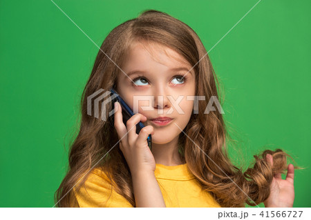 The happy teen girl standing and smiling against green background. 41566727