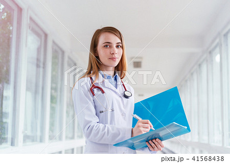 Beautiful young smiling female doctor portrait with folder Beautiful young smiling female doctor portrait with folder 41568438