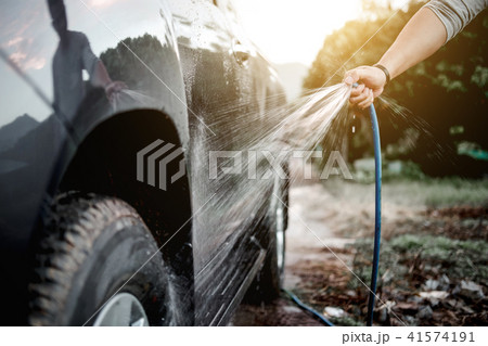 Man washing and cleaning car with spraying pressured water Man washing and cleaning car with spraying pressured water 41574191