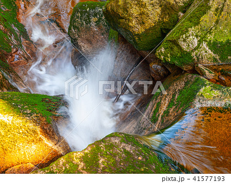 Water cascade of small creek between mossy stones. Long exposure. 41577193