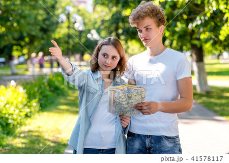 The girl shows the man direction of movement. Summer in nature. The passer-by shows where to go to 41578117