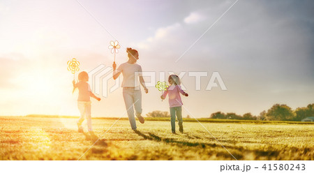 mother and two daughters are playing on meadow mother and two daughters are playing on meadow 41580243