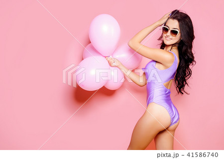 Sexy Lady in bodysuit, sunglasses slim figure, young and healthy posing with balloons on pink 41586740