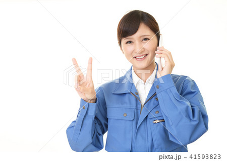 スマートフォンで通話中の女性作業員 スマートフォンで通話中の女性作業員 41593823