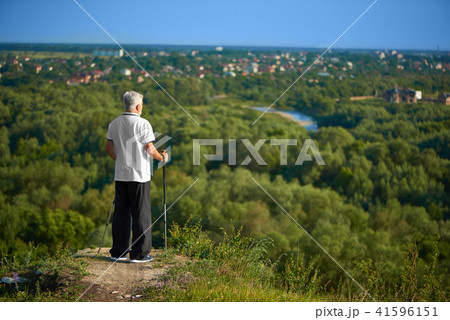 Old man watching beatiful panorame keeping tracking sticks. Old man watching beatiful panorame keeping tracking sticks. 41596151