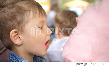 Baby eating cotton candy in the Park. Sweet and airy dessert Baby eating cotton candy in the Park. Sweet and airy dessert 41598358
