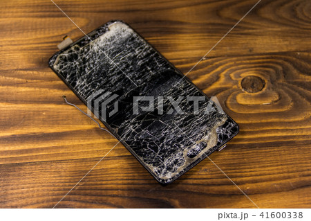 Smartphone with broken screen on wooden background 41600338