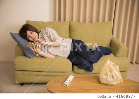 寝転んでスマホを見る若い女性 寝転んでスマホを見る若い女性 41609877