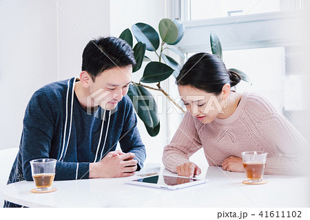 タブレットPCを見て会話するカップル 41611102