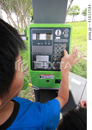 公衆電話で連絡する少年 41613584