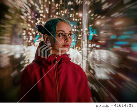 Young beautiful girl with blue dyed unusual hair, transparent glasses, piercing standing at night 41614505