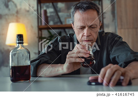 Grey-haired man feeling in despair suffering from alcohol addiction 41616745