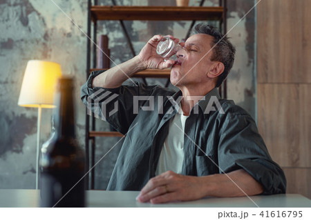Alcohol addicted man finishing his glass of whisky 41616795