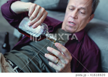 Angry sad man pouring cognac in glass Angry sad man pouring cognac in glass 41616920