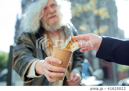Kind-hearted man helping homeless outside 41620022