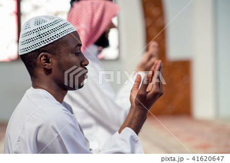 Two religious muslim man praying together inside the mosque 41620647