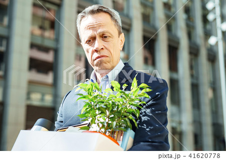 Man removing his decorative plant from office after retirement 41620778