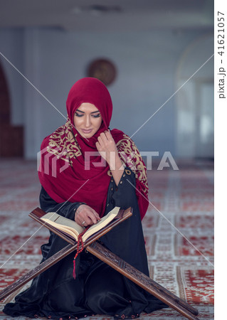 Muslim Woman Reading Koran Or Quran Wearing Traditional Dress At The Mosque Muslim Woman Reading Koran Or Quran Wearing Traditional Dress At The Mosque 41621057