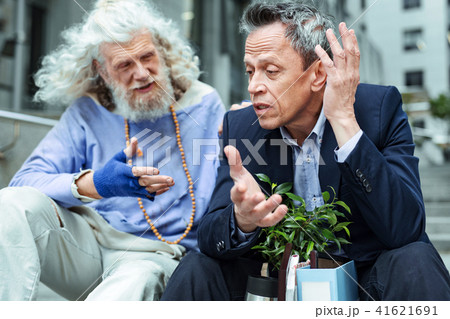 Emotional fired man talking actively to strangely looking hippy Emotional fired man talking actively to strangely looking hippy 41621691