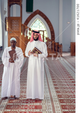 Two religious muslim man walking together inside the mosque 41621700