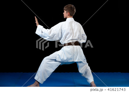 Young boy training karate on black background 41621743