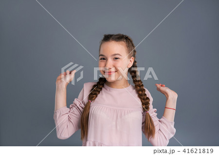 Cute cheerful girl raising her hands happily Cute cheerful girl raising her hands happily 41621819
