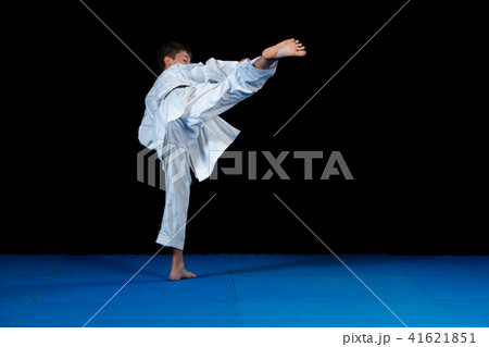 Young boy training karate on black background 41621851