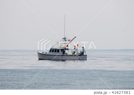 Small white boat in the ocean Small white boat in the ocean 41627361