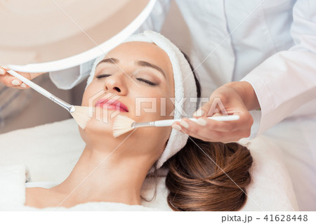 Beautiful woman during anti-aging facial massage in a modern cosmetic center Beautiful woman during anti-aging facial massage in a modern cosmetic center 41628448