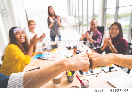 Coworkers fist bump in meeting, teamwork concept 41628493
