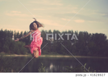 Tattooed Woman Jumping over the Lake Tattooed Woman Jumping over the Lake 41628927