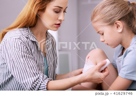 Sad cheerless girl looking at her leg 41629746