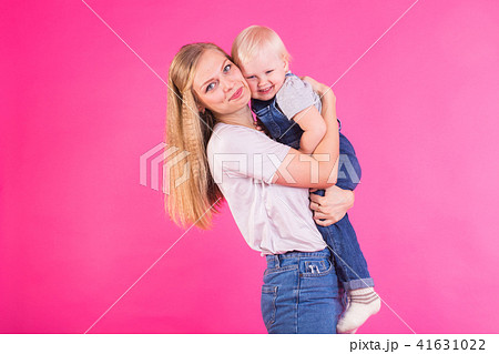 Funny family on pink background. Mother and her daughter girl. Mom and child are having fun. Funny family on pink background. Mother and her daughter girl. Mom and child are having fun. 41631022