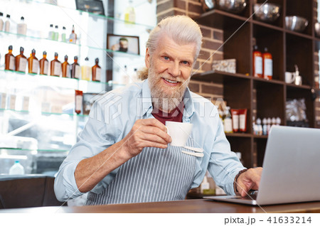 Cheerful barber drinking coffee at workplace 41633214