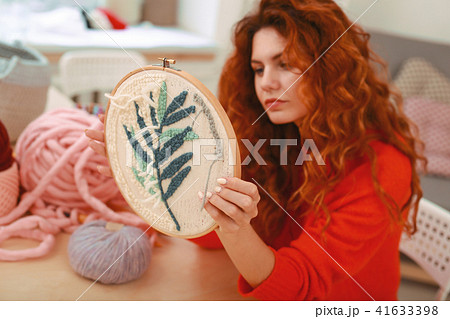 Enthusiastic young girl embroidering little branch Enthusiastic young girl embroidering little branch 41633398