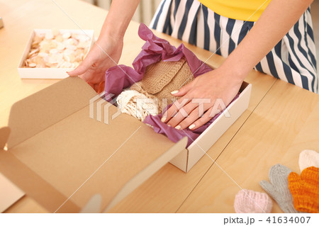 Craftswoman packing little pullovers for children Craftswoman packing little pullovers for children 41634007