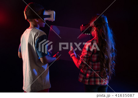 Interested boy and a girl playing VR games Interested boy and a girl playing VR games 41635087
