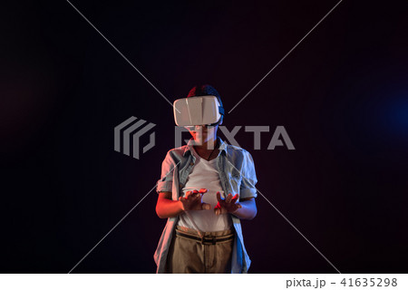 Content boy wearing a modern VR headset Content boy wearing a modern VR headset 41635298