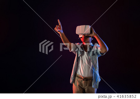 Concentrated boy wearing a modern VR headset Concentrated boy wearing a modern VR headset 41635852