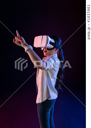 Amazed schoolgirl wearing a VR headset Amazed schoolgirl wearing a VR headset 41635861