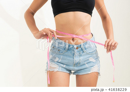 Slender woman measuring her waist with metric tape measure after a diet,  isolated 16406784 PNG