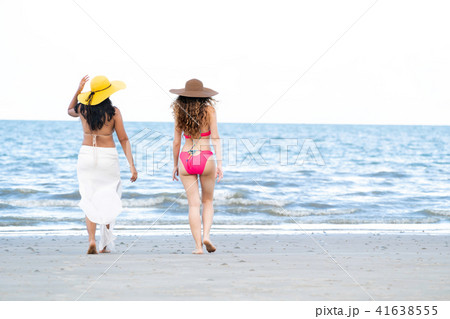 Happy women go sunbathing at sand beach in summer. 41638555