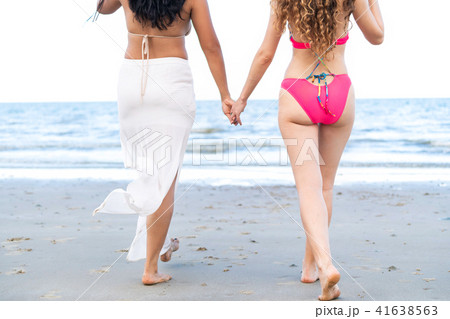 Happy women go sunbathing at sand beach in summer. Happy women go sunbathing at sand beach in summer. 41638563