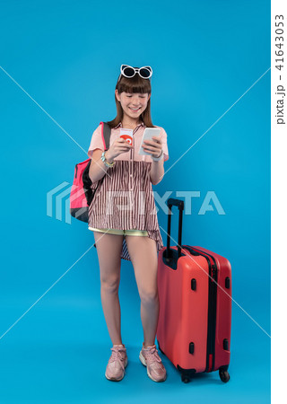 Exuberant girl standing with her phone Exuberant girl standing with her phone 41643053