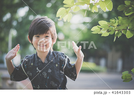 A little lovely boy in a kimono playing in a park A little lovely boy in a kimono playing in a park 41643303