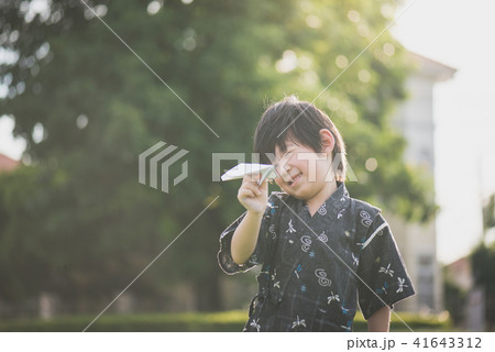 child in kimono playing paper plane outdoors child in kimono playing paper plane outdoors 41643312