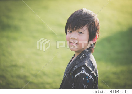 Asian boy in kimono with green field background Asian boy in kimono with green field background 41643313