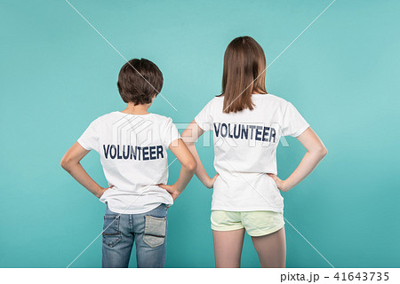 Young volunteers holding their hands on their waists Young volunteers holding their hands on their waists 41643735